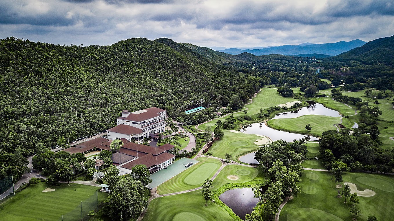 Alpine Golf Resort Chiang Mai, fairway set in a valley below forested mountains in northern Thailand