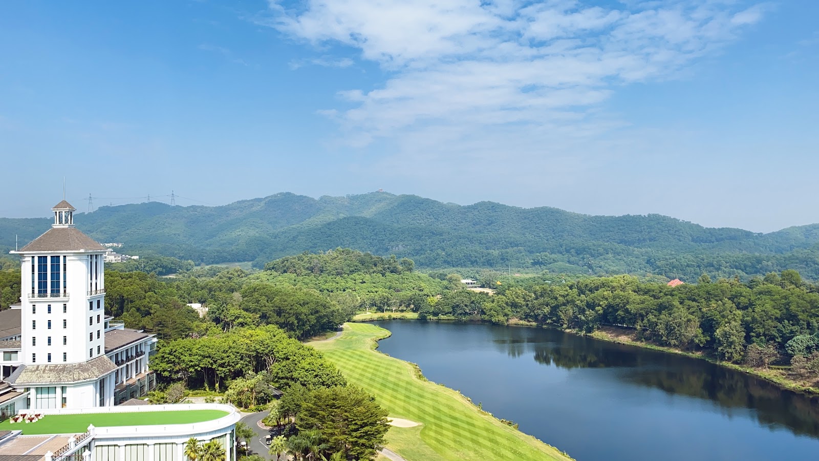 Tropical resort golf course framed by palms and ocean in Southeast Asia