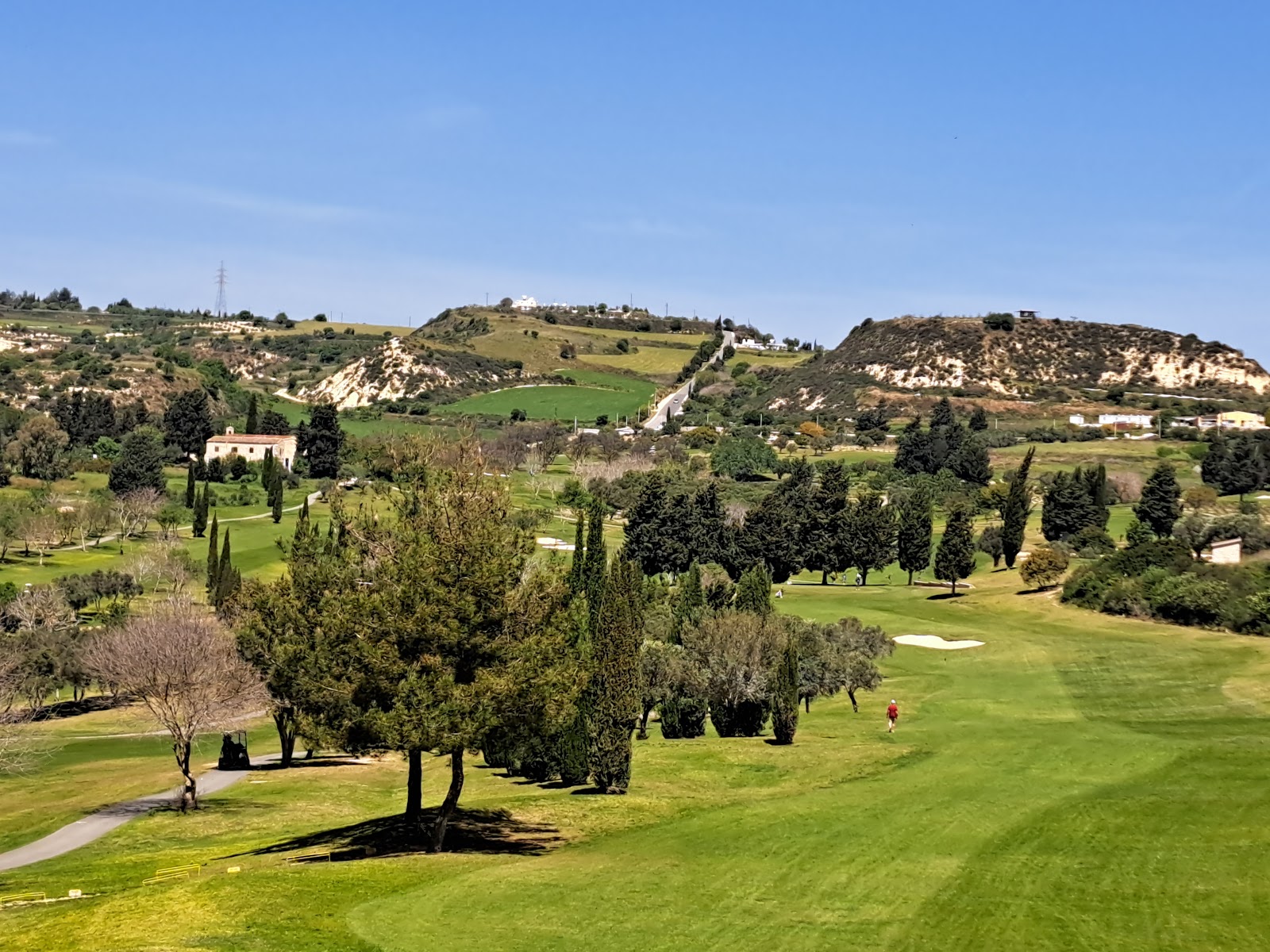 Minthis Golf Club, fairway winding through olive groves and hills above Paphos, Cyprus