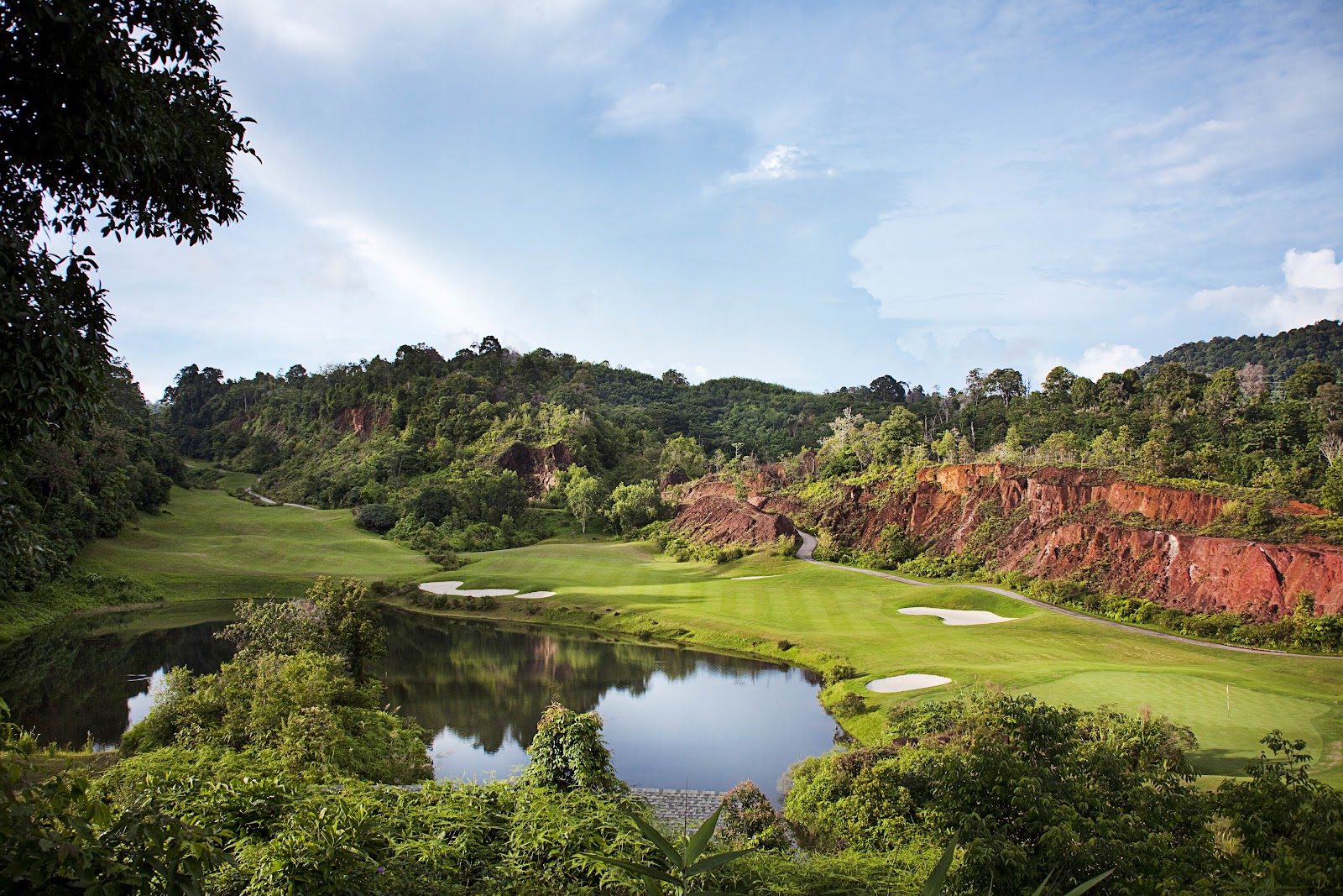 Red Mountain Golf Club in Phuket, fairways and lakes set beneath the rust red cliffs of the old tin mine