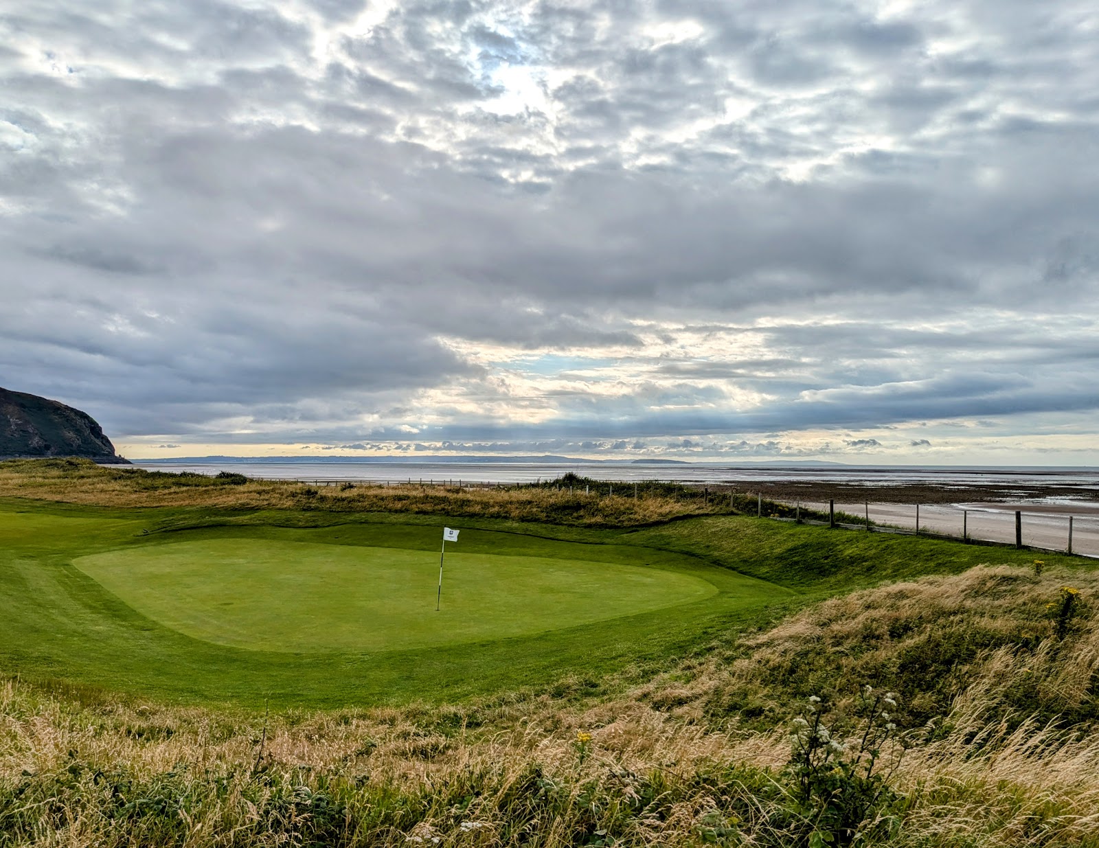 Conwy Caernarvonshire Golf Club, links fairway on the Morfa peninsula with the hills of Snowdonia beyond